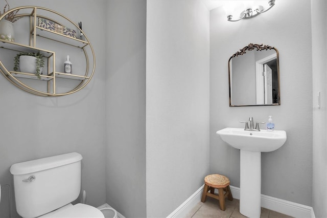 bathroom with sink, toilet, and tile patterned flooring