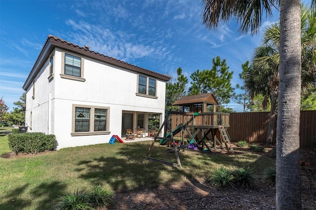 back of house featuring a yard and a playground