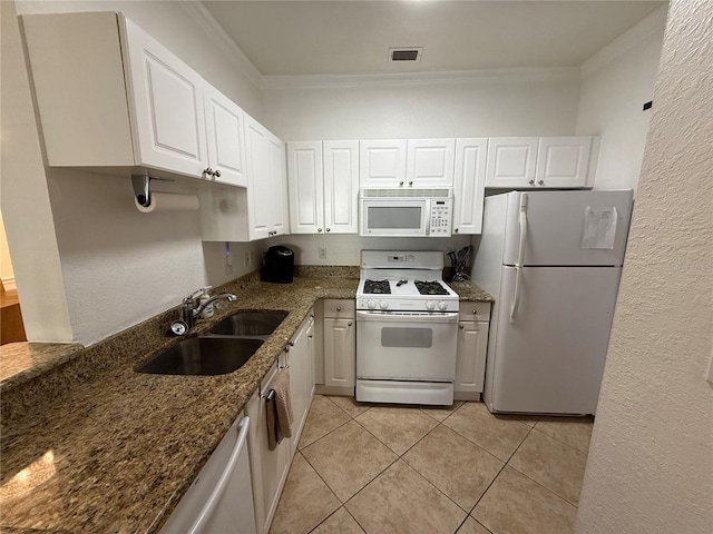 kitchen with sink, white cabinets, dark stone counters, and white appliances