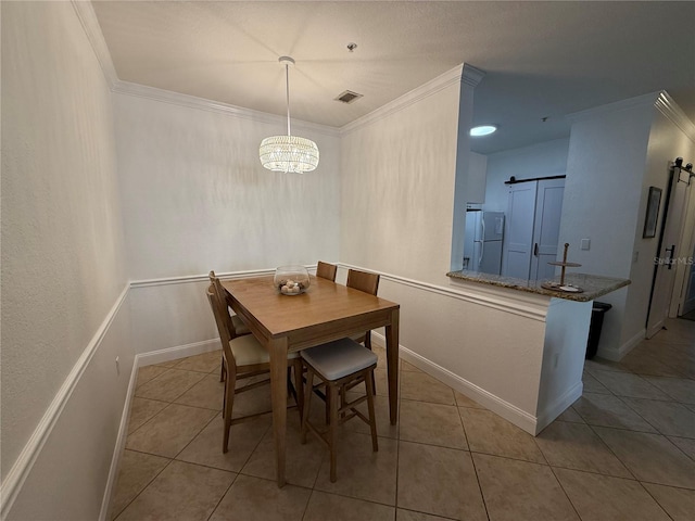 tiled dining room featuring a barn door, crown molding, and a notable chandelier