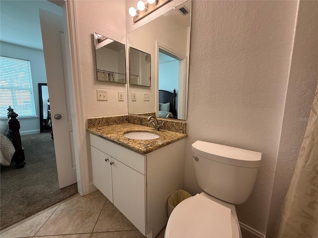 bathroom featuring tile patterned flooring, vanity, and toilet