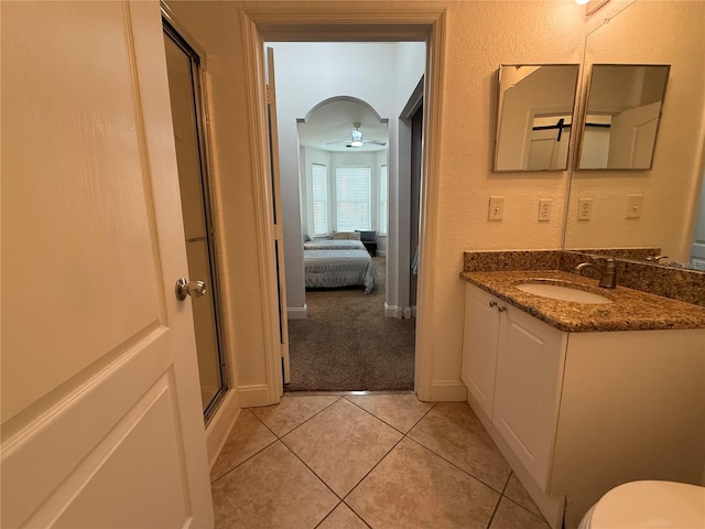 bathroom featuring tile patterned floors, ceiling fan, vanity, and an enclosed shower