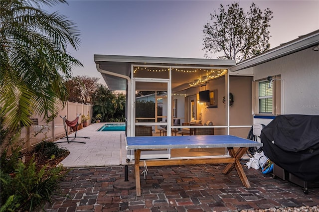 view of patio / terrace with a fenced in pool, a grill, and a sunroom