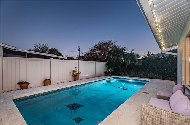 pool at dusk featuring a patio