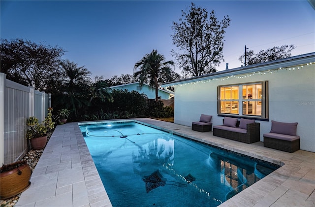 pool at dusk featuring a patio