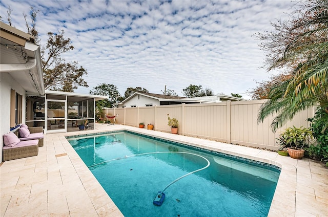 view of swimming pool with a patio area and a sunroom