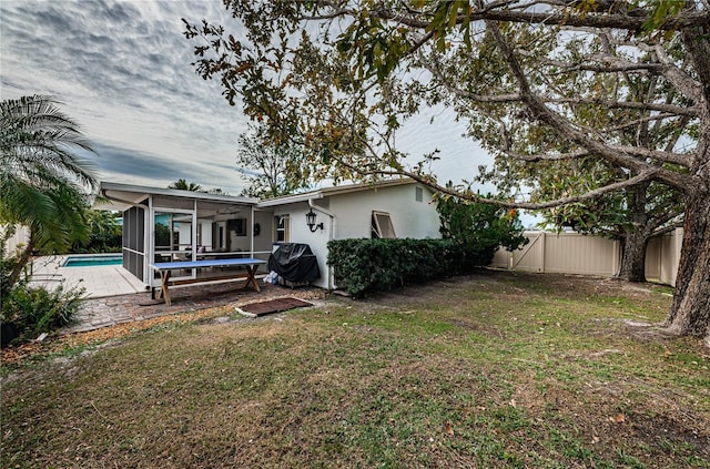 rear view of house with a lawn, a patio area, a sunroom, and ceiling fan