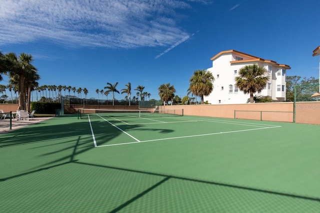 view of tennis court with basketball hoop