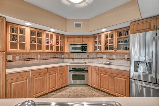 kitchen featuring tasteful backsplash, appliances with stainless steel finishes, and light tile patterned floors