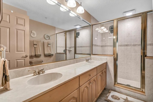 bathroom featuring vanity, tile patterned floors, a textured ceiling, and walk in shower