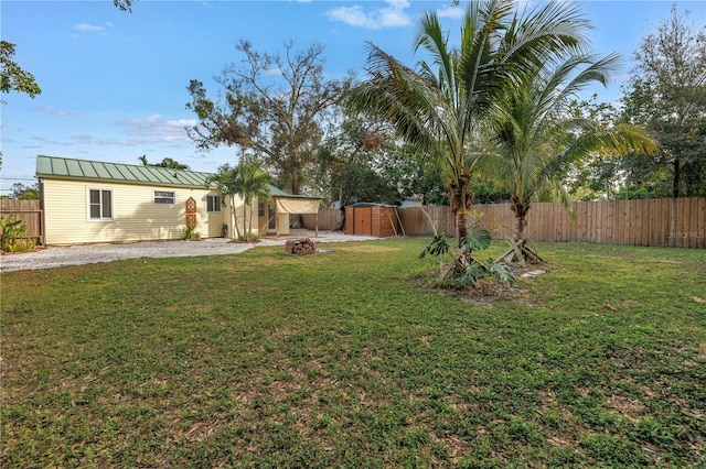 view of yard featuring a storage unit, an outdoor structure, and a fenced backyard