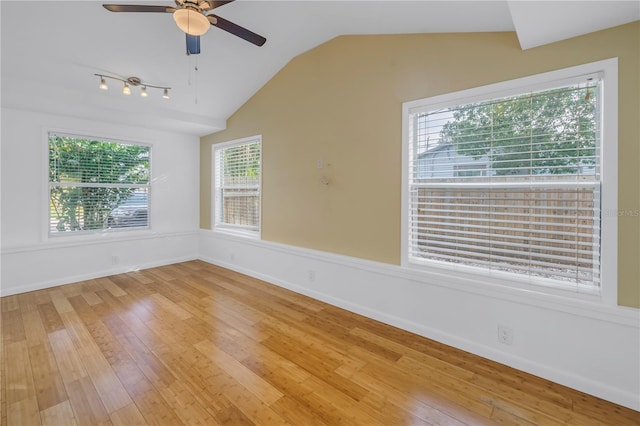 unfurnished room with ceiling fan, baseboards, vaulted ceiling, and wood finished floors