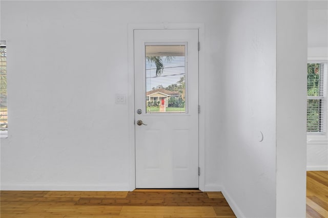 doorway to outside with light wood-style flooring and baseboards