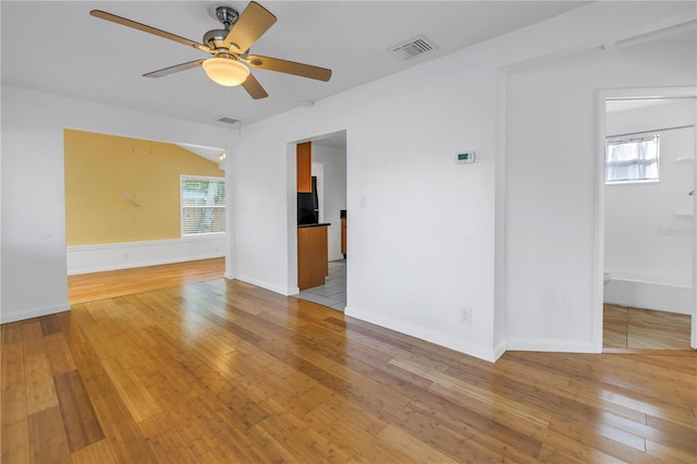 unfurnished room with light wood-style floors, visible vents, plenty of natural light, and ceiling fan