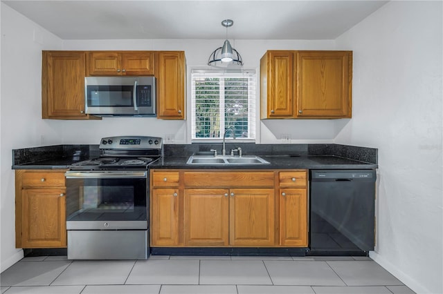 kitchen featuring stainless steel appliances, brown cabinetry, a sink, and pendant lighting