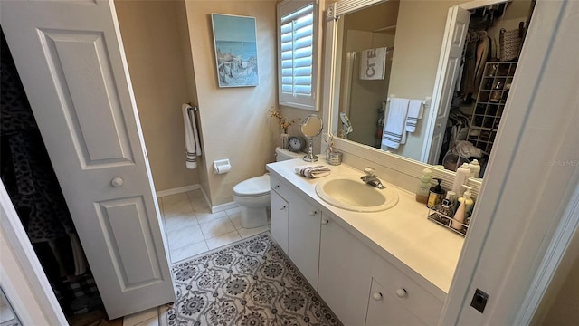 bathroom with toilet, vanity, and tile patterned flooring