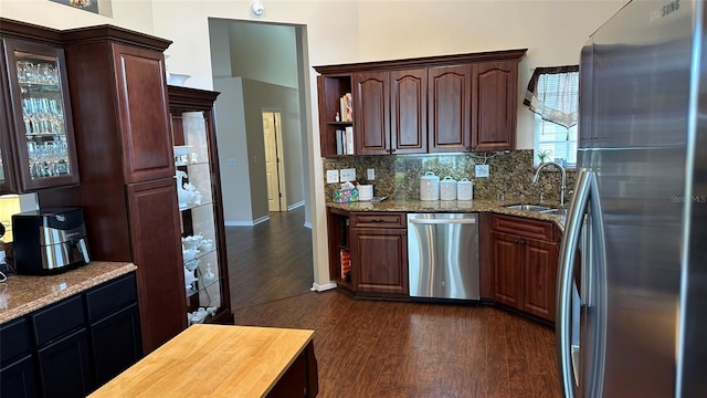 kitchen featuring appliances with stainless steel finishes, backsplash, dark hardwood / wood-style flooring, dark brown cabinets, and sink