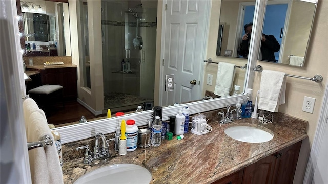 bathroom with vanity and a shower with door