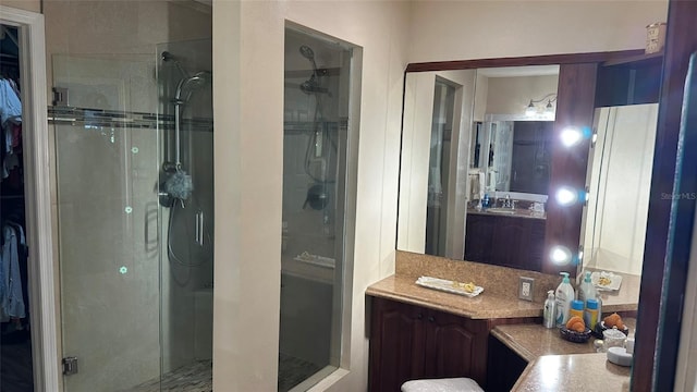 bathroom with a shower with shower door and vanity