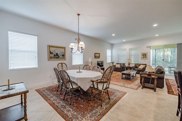 dining space with light tile patterned floors and an inviting chandelier