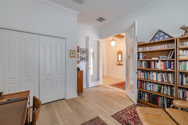 living area featuring french doors, ornamental molding, and light hardwood / wood-style flooring