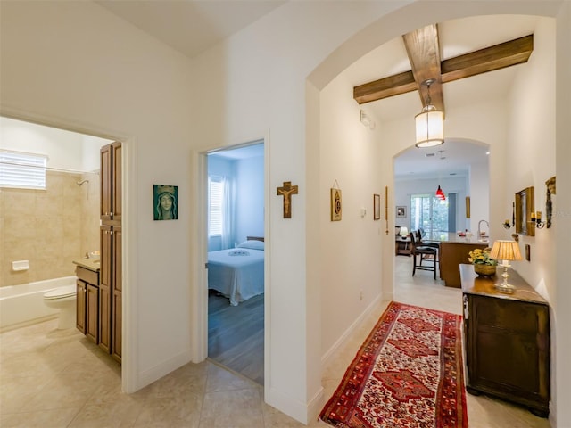 hall with beam ceiling, light tile patterned floors, and coffered ceiling