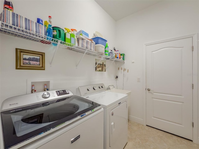 laundry area featuring washing machine and dryer and light tile patterned floors