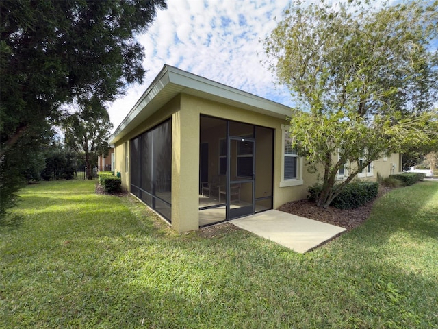 rear view of property featuring a lawn and a sunroom