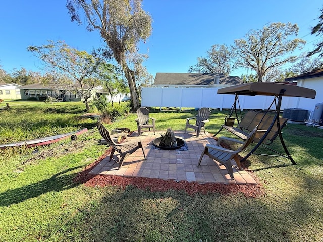 view of yard with a fire pit, a patio area, and central AC