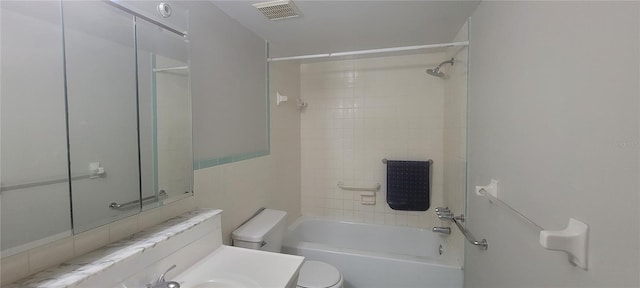 bathroom featuring tiled shower / bath and toilet