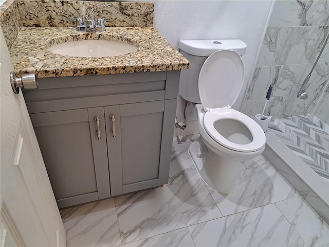 bathroom with walk in shower, vanity, and toilet