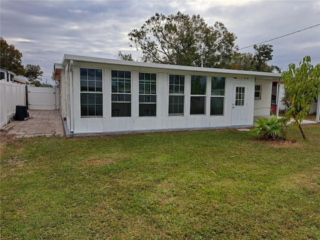 rear view of property with a patio area and a lawn