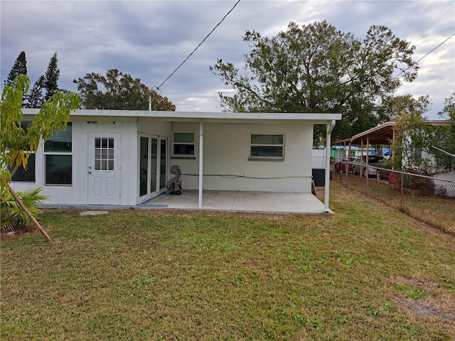 rear view of house with a patio and a lawn