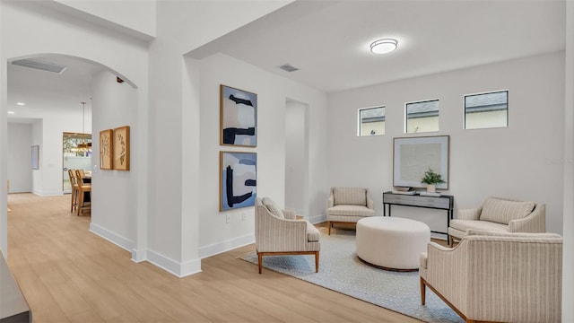 living area featuring a notable chandelier and light wood-type flooring