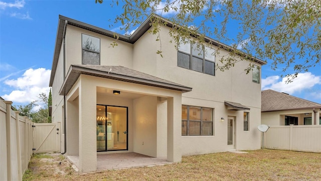 rear view of property featuring a yard and a patio