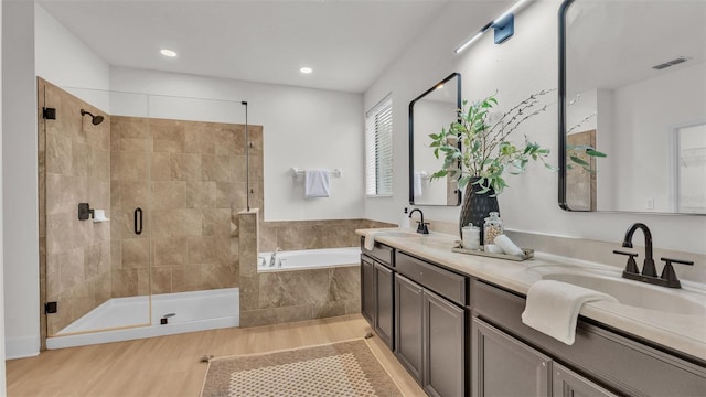 bathroom featuring vanity and independent shower and bath