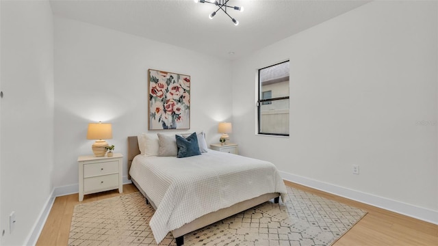 bedroom featuring a notable chandelier and light wood-type flooring