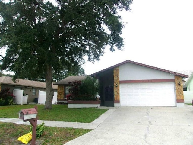 ranch-style home with a garage and a front lawn