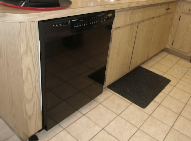 room details featuring light brown cabinets and black dishwasher