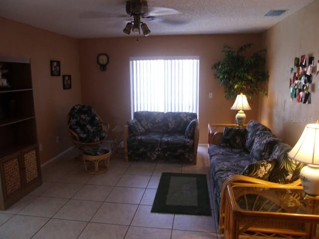 tiled living room featuring ceiling fan and a textured ceiling