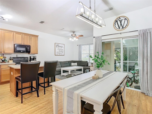 dining room with light wood-type flooring and ceiling fan