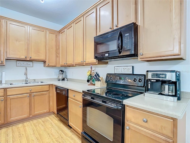 kitchen featuring sink, black appliances, and light wood-type flooring