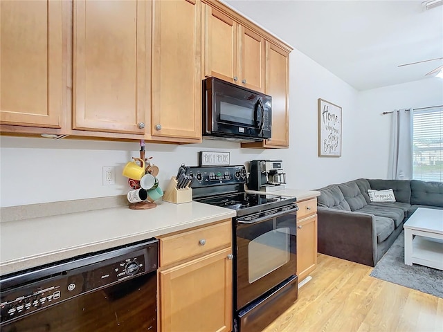 kitchen with light brown cabinetry, black appliances, and light hardwood / wood-style floors