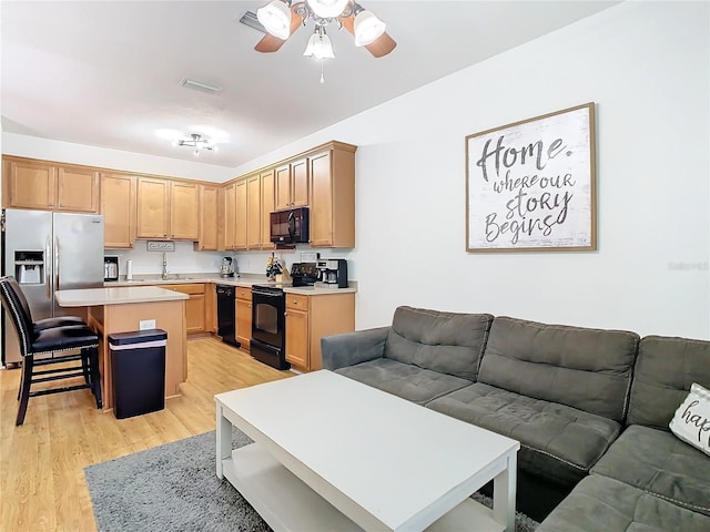 living room featuring light hardwood / wood-style floors and ceiling fan