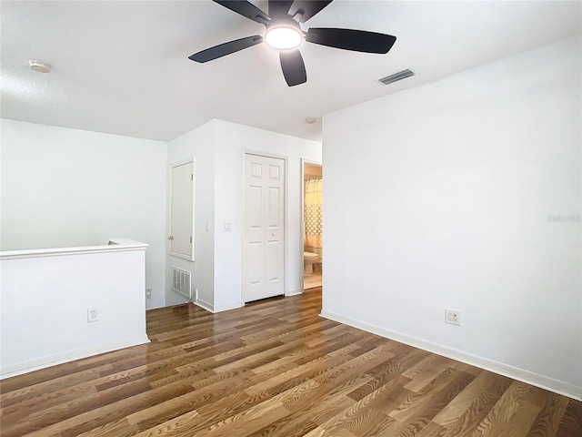 empty room with ceiling fan and dark wood-type flooring