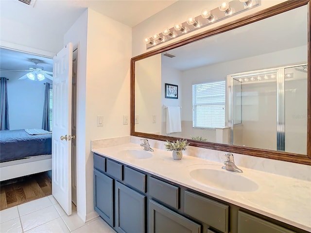 bathroom with tile patterned flooring, ceiling fan, an enclosed shower, and vanity