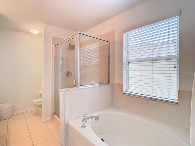 bathroom featuring plus walk in shower, tile patterned floors, and toilet