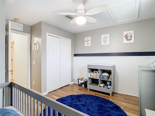 bedroom with ceiling fan, a closet, and light hardwood / wood-style floors