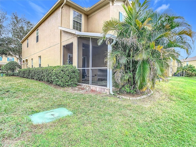 view of side of home with a sunroom and a yard