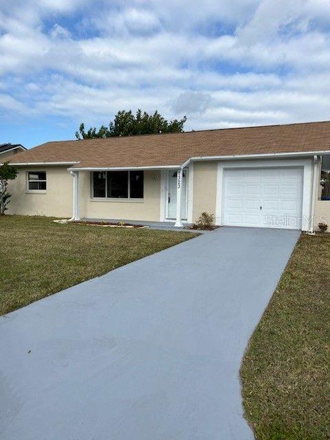 ranch-style home with a front yard and a garage